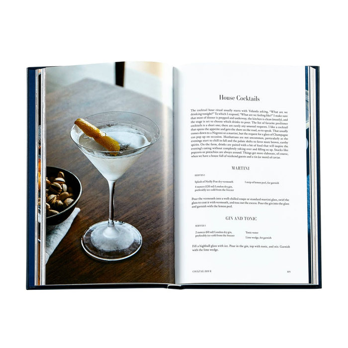 Open book showing a cocktail recipe with a martini glass on a wooden table.