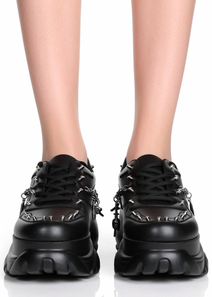 Front on-foot view of Anthony Wang DYNAMITE Bass Stomp black platform sneakers showcasing the classic lace-up front and bold silver chain detailing