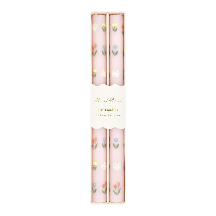 Two floral-patterned candles in pink packaging on a white background