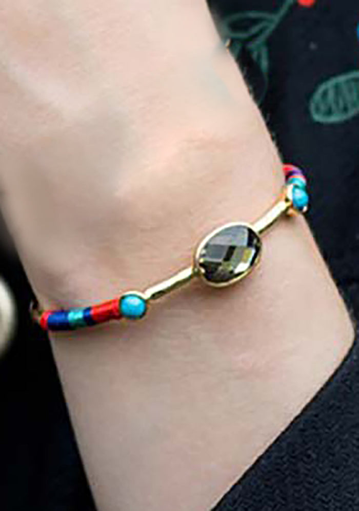 Hipanema Valmy Bangle in gold amber with handwoven thread detail and stone accents on festival bracelet — model view