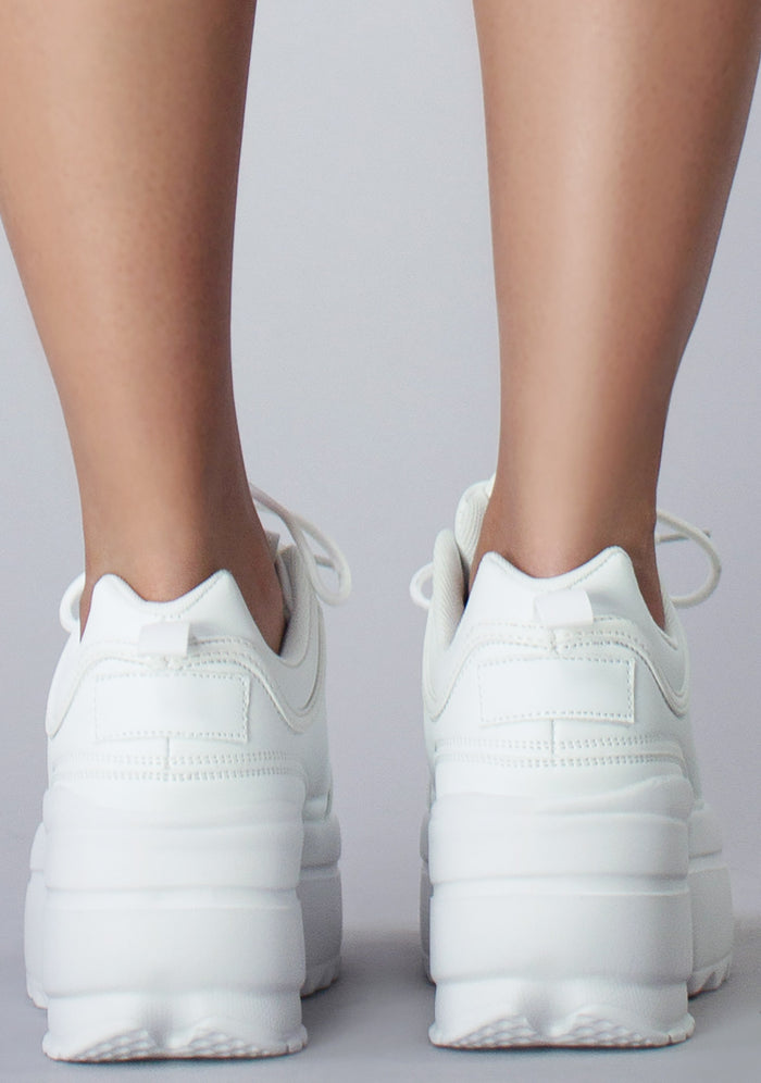 Close-up rear shot of the chunky 2-inch white platform outsoles on-model, emphasizing the rugged texture built for festival comfort.