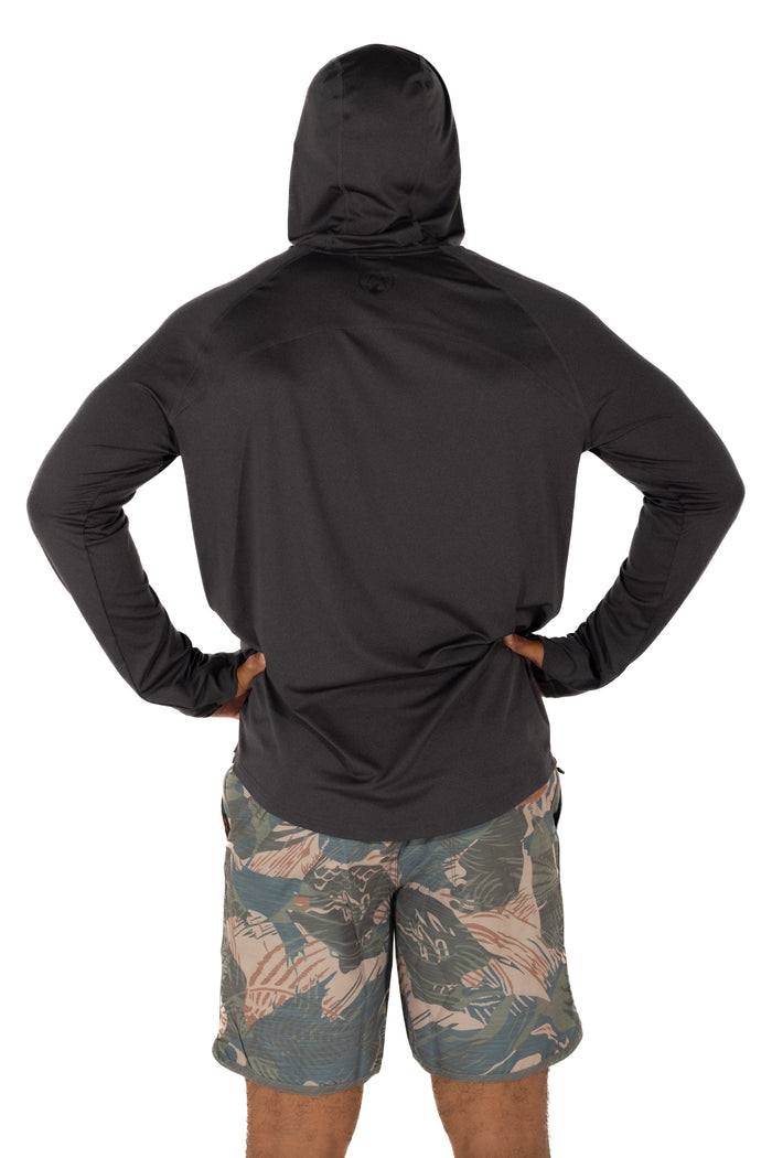 Back view of a man wearing the Waihana Mariner Black Hooded Long Sleeve sun shirt with tropical-print board shorts on a white studio background.