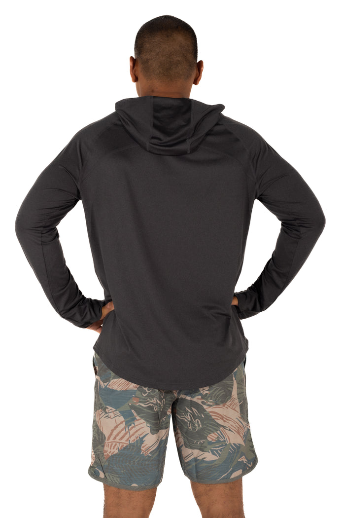 Back view of a male model wearing the Waihana Mariner Black Hooded Long Sleeve sun shirt with tropical print board shorts on a white background.