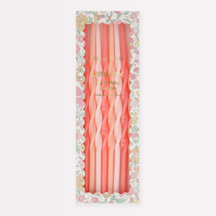 A boxed set of six twisted taper candles in soft pink and peach tones, displayed in a floral-patterned package on a light gray background.
