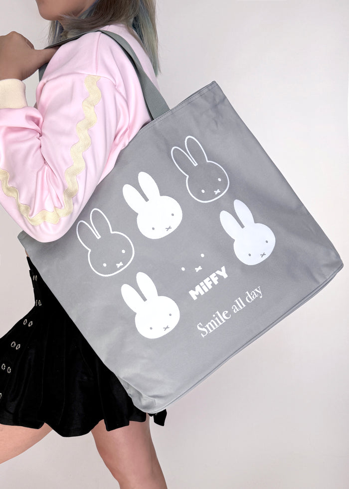 Miffy Smile Large Beach Tote in grey with full-front Miffy smile graphic on durable poly-canvas beach tote bag — model view