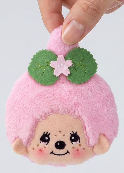 Sekiguchi Monchhichi-Chan Sakura Mochi Pink Plush Coin Bag held in hand showing sakura flower and double green leaf detail — detail view