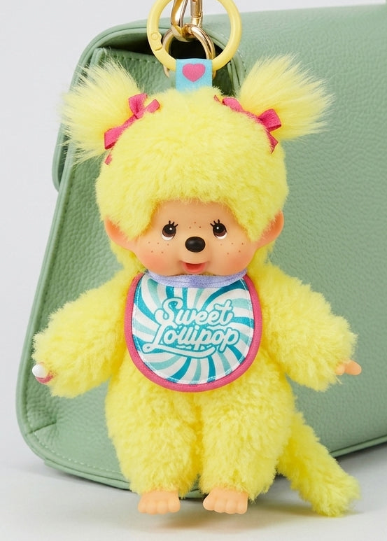 Sekiguchi Monchhichi Sweet Lollipop Yellow Plush Mascot Keychain clipped to green bag — styled view