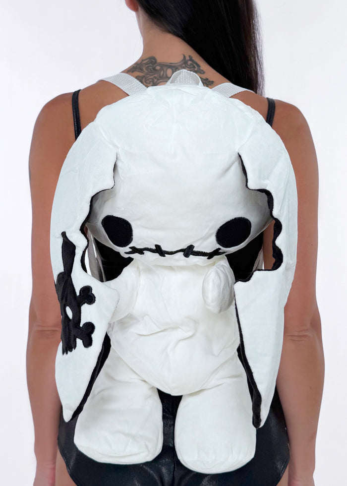 Sleepyville Critters Naughty Bunny Glow in the Dark Plush Backpack in white black with 3D bunny plush, glow-in-the-dark face, and skull patch ear on kawaii goth rave backpack — model front view