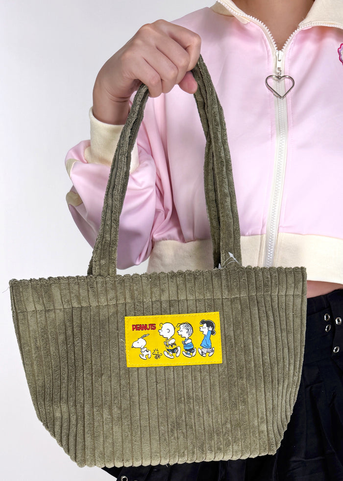 Peanuts Snoopy and the Gang Corduroy Tote in olive with Snoopy and the Gang woven patch on soft corduroy festival tote bag — model view