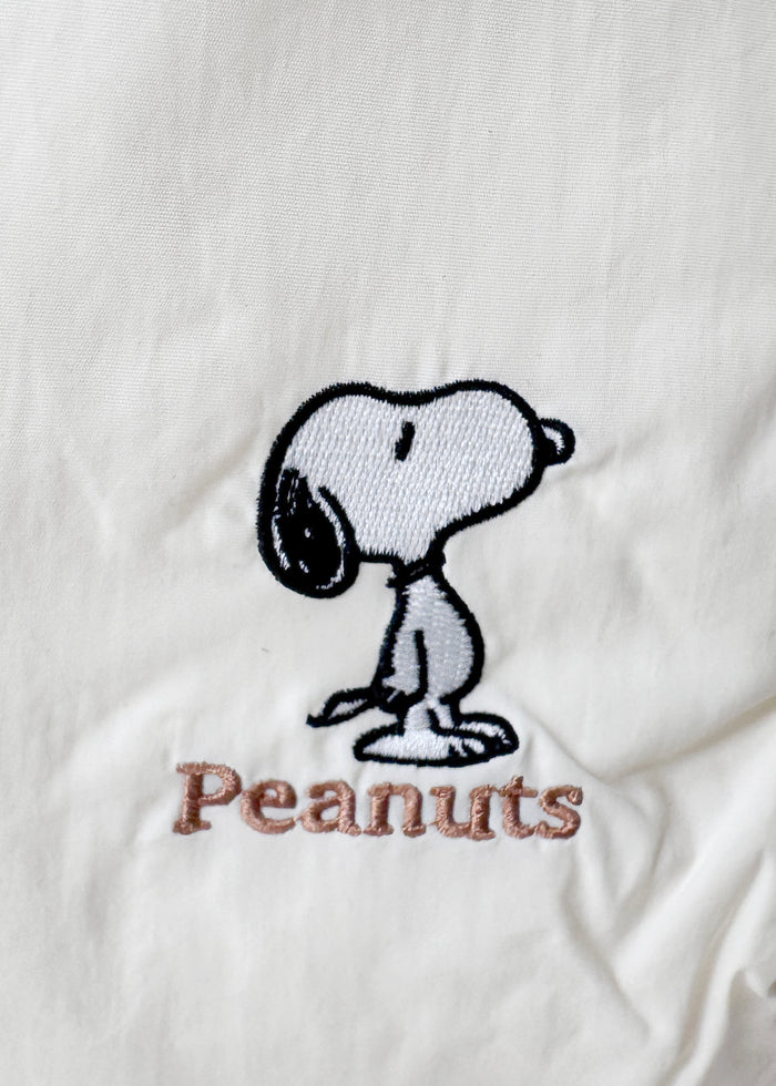 Peanuts Snoopy Classic Medium Nylon Ivory Shoulder Bag in ivory with Snoopy classic embroidery on water-resistant nylon shoulder crossbody bag — strap detail view