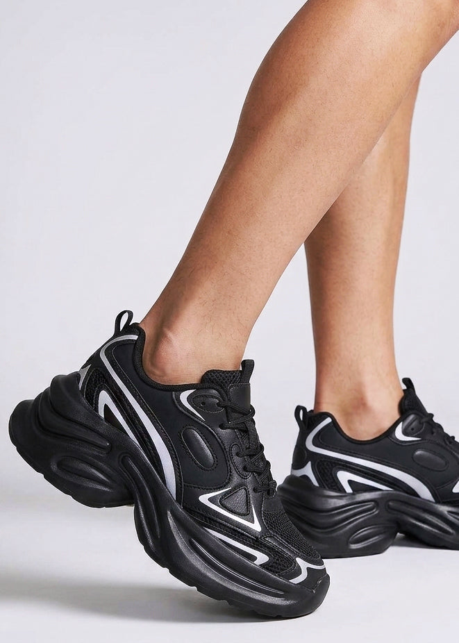 Berness Petra Tektronic Black Platform Sneakers in black with metallic silver strip detailing on chunky platform sneaker — front view, on foot, angled