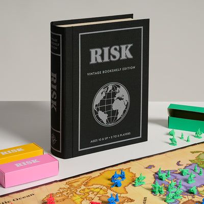Risk board game book edition with game pieces on a world map