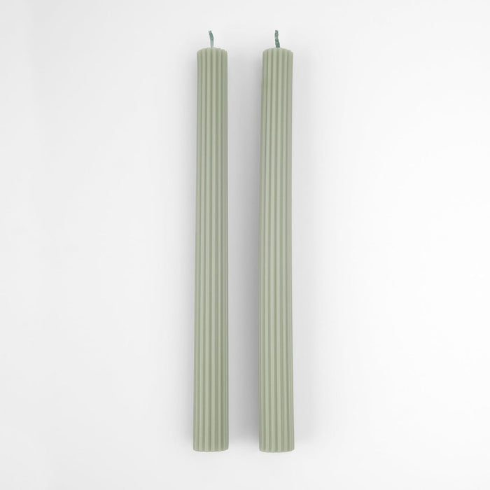 Two green candles on a white background
