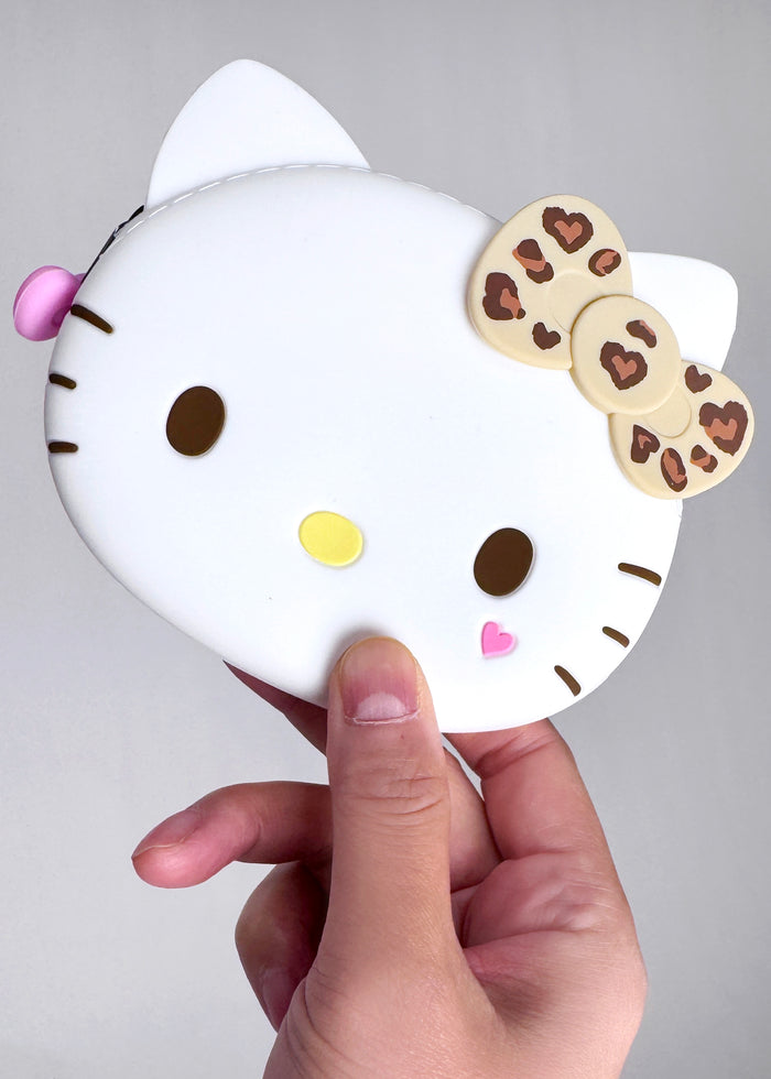 Sanrio Hello Kitty Leopard 3D Silicone Pouch in leopard print with 3D Hello Kitty face on silicone cosmetic makeup bag — model view