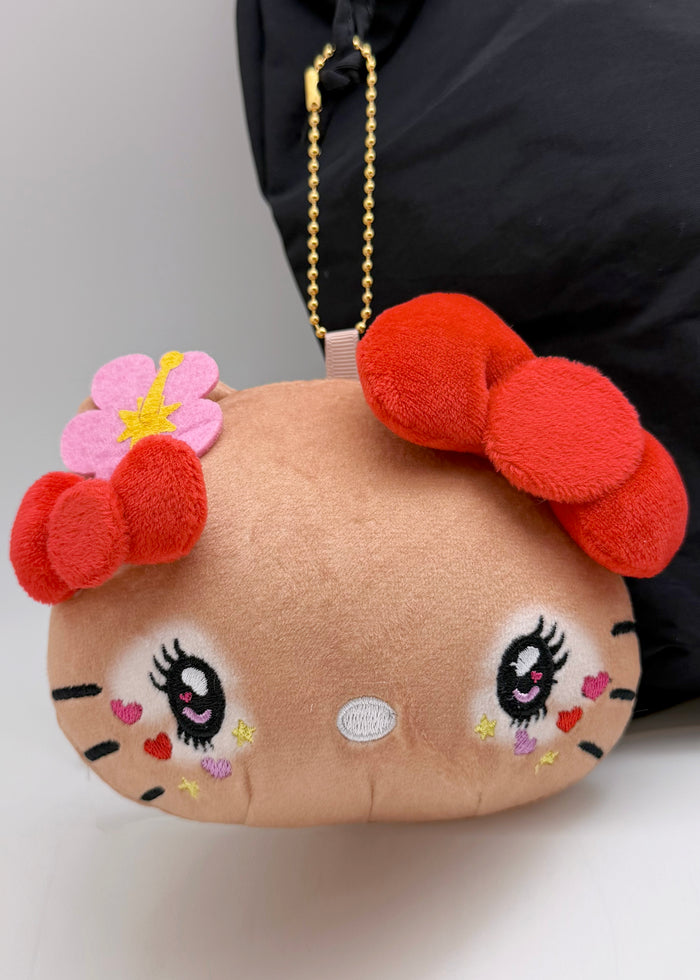 Sanrio Tanned Hello Kitty Hibiscus Face Plush Coin Pouch in brown with tanned Hello Kitty in hibiscus floral design on soft plush coin pouch — model view