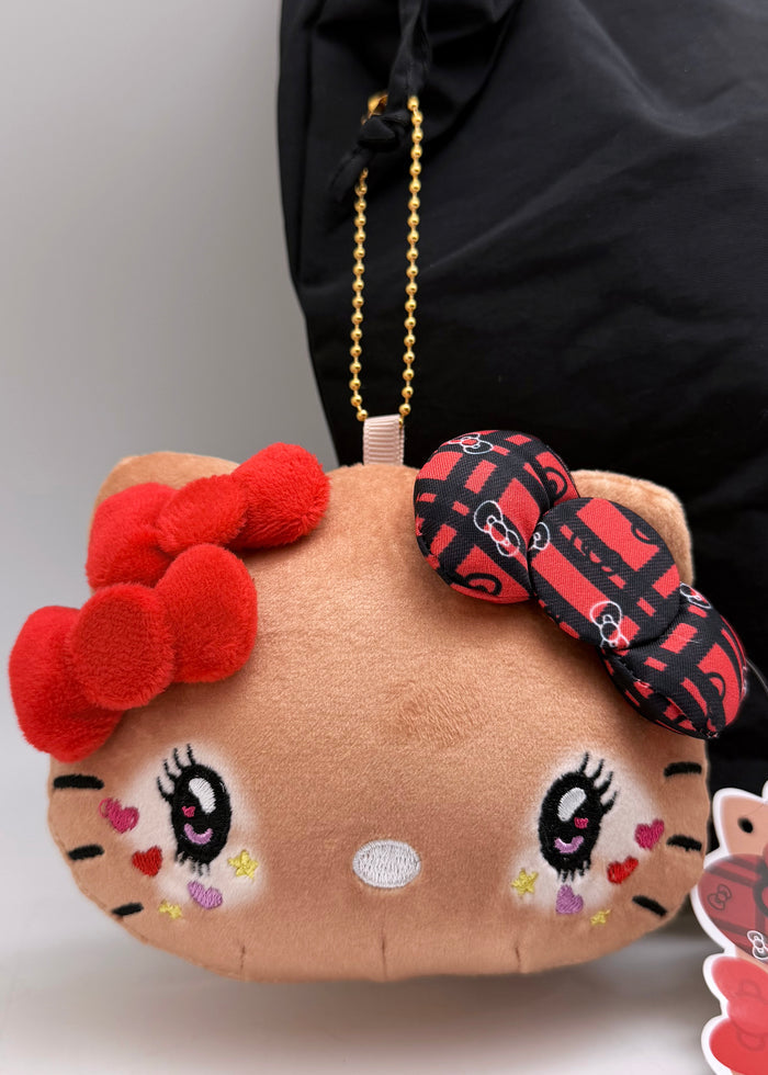 Sanrio Tanned Hello Kitty Student Face Plush Coin Pouch in brown with tanned Hello Kitty in student uniform on soft plush coin pouch — model view