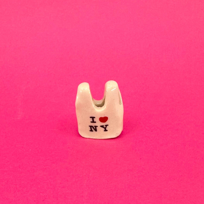Small white bag charm with 'I ❤️ NY' text on a pink background