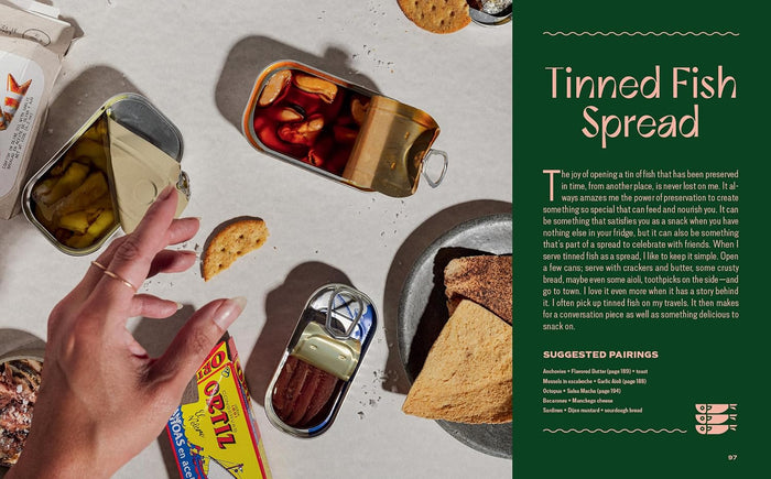 Tins of canned fish with crackers on a table, next to text about tinned fish spread.