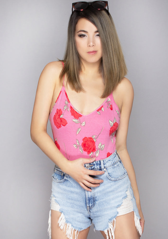 Motel Rocks Tahiti Candy Rose Bodysuit in pink with all-over candy rose graphic and spaghetti straps on rave bodysuit — model view